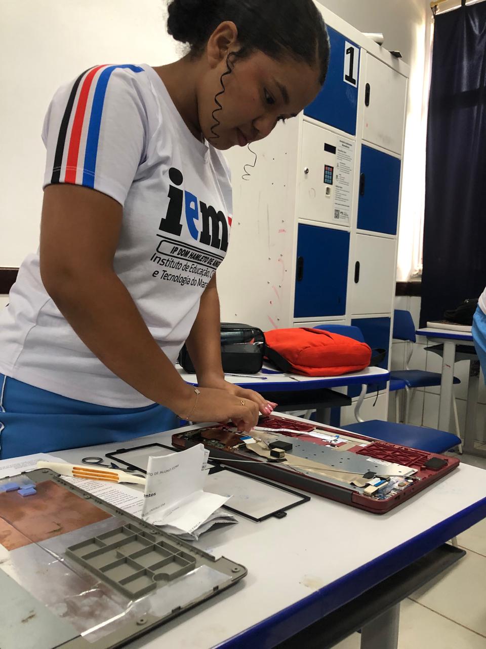 Aluno realizando manutenção em um notebook